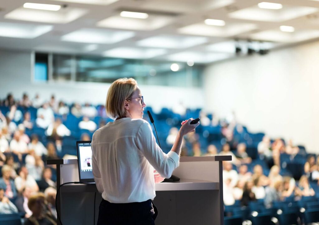 A speaker giving a talk during a conference and using CTI Presentation Management Software.